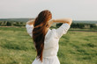 © Galina Zhigalova - Close up portrait of beautiful carefree long hair girl in white clothes in field, view from back. Sensitivity to nature concept