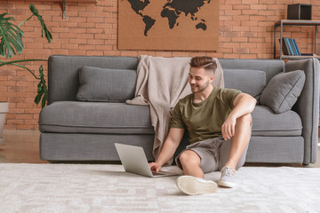 Canvas Print - Handsome man with laptop resting at home