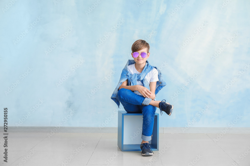 Stylish boy in jeans clothes near color wall