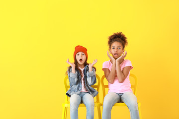 Wall Mural - Shocked girls in jeans on color background