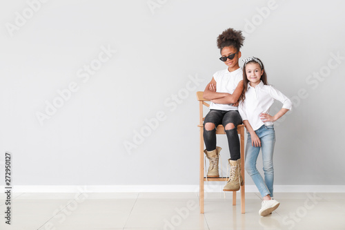Fotografía Stylish girls in jeans near grey wall