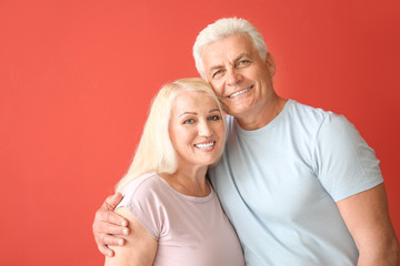 Wall Mural - Portrait of happy mature couple on color background