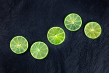 Lime Slices, Shot From Above On A Black Background With Copy Space