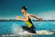 © master1305 - Professional triathlete swimming in river's open water. Man wearing swim equipment practicing triathlon on the beach in summer's day. Concept of healthy lifestyle, sport, action, motion and movement.