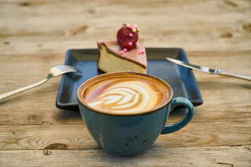 Latte coffee and cheesecake on the wooden table