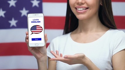 Learn English language app on cellphone in female hand, USA flag on background