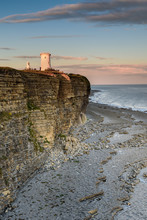 Nash Point Lighthouse, South Wales, At Sunset.  The Lighthouse Sits On The Top Of Steep Cliffs, Overlooking The Bristol Channel