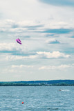 Fototapeta  - A kiteboarder is pulled across water by a power kite. Kitesurfer high in flight