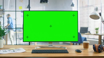 Aufkleber - Wide Green Mock-up Screen Desktop Computer Standing on the Desk in the Modern Creative Office. In the Background Bright Creative Loft for Developers and Designers where Professional Working. Zoom In 