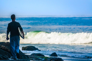 Surfer Walks Towards the Ocean in Morning