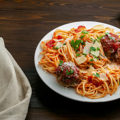 Wall Mural - Pasta with meatballs, parmesan and tomato sauce on a plate.  Homemade Italian spaghetti on a rustic wooden table.