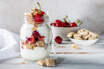 Bitesize shredded wheat with fresh cherry berries in Jar