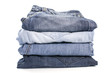 © Christina - Denim blue jeans stack on white background. Clothes, fashion, charity