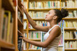 © Samuel B. - Black african american young girl student studying at the school university library