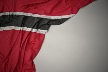 Wall Mural - waving national flag of trinidad and tobago on a gray background.