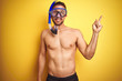 © Krakenimages.com - Young handsome shirtless man wearing diving goggles over isolated yellow background very happy pointing with hand and finger to the side