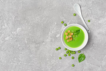 Soup of green peas with basil leaves and croutons