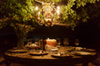 © Natalie Faye - Outdoor dining table with rustic decor and chandelier