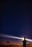 Fototapeta Kosmos - lighthouse at night with moon and stars