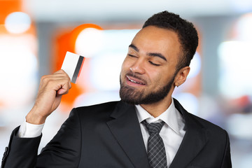 Wall Mural - young successful businessman man in a stylish black classic suit holding a plastic credit card