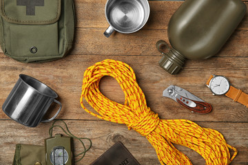 Flat lay composition with camping equipment on wooden background