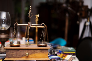 Many kind of old fashioned balance scales on wooden table. Colorful ancient balance scales in vintage background, isolated. the symbol of Lawyer. Royalty high quality free stock image.