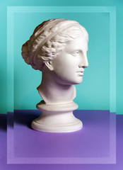 Wall Mural - White gypsum copy of ancient statue Venus head on a green purple background. Plaster sculpture woman face.