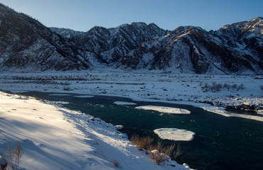 Wall Mural - Winter frozen mountain river under ice and snow