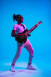 © master1305 - Young african-american musician playing the guitar like a rockstar on blue studio background in neon light. Concept of music, hobby. Joyful attractive guy improvising. Retro colorful portrait.