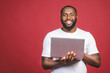 © denis_vermenko - Excited happy afro american man with computer screen and celebrating the win isolated over red background.