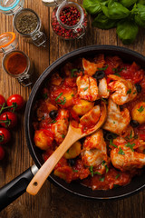 traditionally prepared cod in spanish. served in tomato sauce with boiled potatoes, olivki and basil