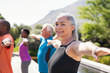 © Rido - Senior woman stretching arms in yoga class