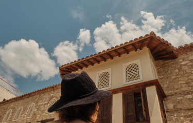 woman or girl with hat looking the oldest house in a sunny day in the city of Athens - travel destination.