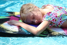Girl Napping On A Kickboard In The Pool