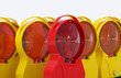 Baustelle Sperre Symbolbild - Viele Bakenleuchten Baustellenleuchten - eine rote Signalleuchte im Vordergrund - neutraler Hintergrund