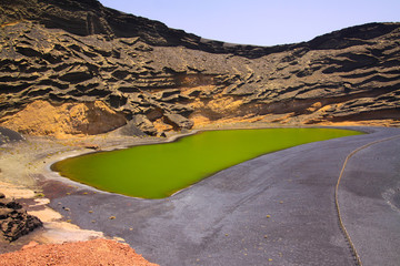 View on secluded deep green lake (Lago verde) in lagoon surrounded by impressive cliffs - El Golfo, Lanzarote