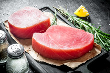 Raw Tuna Steak On A Cutting Board With Paper.