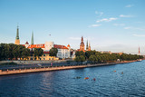 Fototapeta Góry - Panoramic view of the Old Town from the cable-stayed bridge to the Daugava embankment at sunset. Riga, Latvia. Riga Castle with the Riga Cathedral in front of. St. Peter's Church in the background.