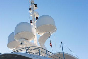 Radars on a white yacht against the blue sky. Navigation equipment, radar and antennas provide safety on board.