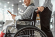 © Yakobchuk Olena - Female worker of airport holding wheelchair with elderly lady