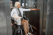 © Yakobchuk Olena - Mature woman in glasses on disabled carriage using elevator