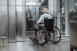 © Yakobchuk Olena - Adult woman on disabled carriage waiting for lift
