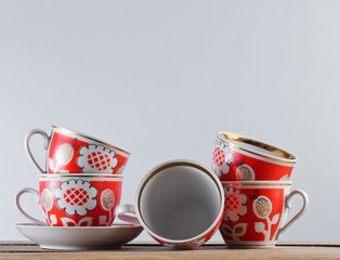 Wall Mural - Many antique ceramic cups on a wooden table against a white wall