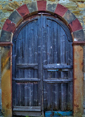 Rustic arched wooden door on traditional mansion in Kambos, Chios, Greece. Old Colorful villa entrance.