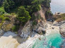Aerial View Of Small Waterfall Landing On A Calm Beach, U.S.A.