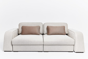 The beige couch in modern style with two brown pillows isolated on white background