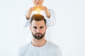 Wall Mural - cropped view of woman putting hands above head of handsome man while standing isolated on white