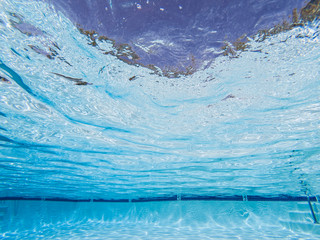 Abstract upwards underwater view in clean suburban swimming pool.