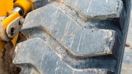 Wall Mural - Panorama Close up view of the huge qnd dirty black tire of a loader