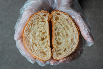 A baker holding in his hands a fresh croissant cut in half